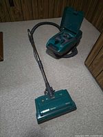 Full view of Kenmore teal canister vacuum with powerhead attached
