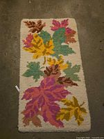 Full view of hand-hooked rug showing maple leaf design and overall condition