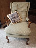 Front view of wingback chair with pillow on seat