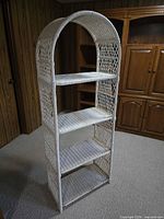 Front view of white wicker arched shelving unit