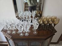 All four sets of wine glasses on cabinet top