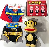 Front view of Superman and Batman diaper covers with capes, Paul Frank Julius monkey lamp and lamp box