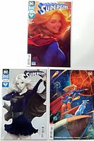 Group shot of three bagged Supergirl issues (#16, two #23) showing covers