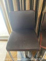 Front view showing black leather seat and backrest with edge piping