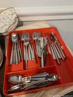 Tray containing assorted stainless steel cutlery pieces
