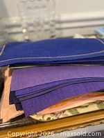 Multiple stacks of cloth placemats in assorted colors and prints on table
