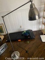 Full view of adjustable metal floor study lamp with dome shade and base