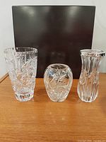 Three of the four cut crystal vases grouped together