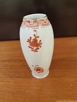 Front view of vase showing orange floral motif and gold band