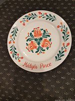 Front of plate showing floral design and Mátyás Pince text