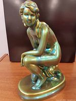 Front-left view of Zsolnay iridescent green kneeling nude figurine