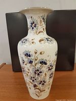 Full view of porcelain vase front, floral pattern visible