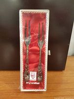 Two silver-plated forks in red-lined box, clear lid shows label "Justinus Solingen 90 g versilbert"