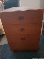 Front view showing three drawers and recessed pulls