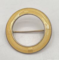 Front view of yellow enamel sterling circular brooch
