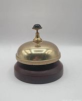 Side view showing brass dome, wood base