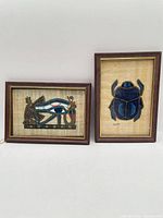 Pair of framed papyrus artworks showing overall view and relative size