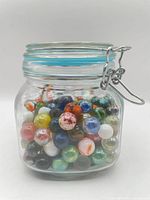 Front view of jar filled with assorted marbles