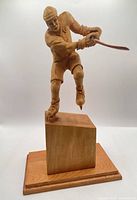 Front view of wooden hockey player on base