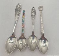 Front view of four sterling silver souvenir spoons