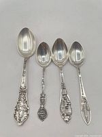 Front view of all four sterling souvenir spoons