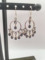 Full view of both chandelier earrings hanging from stand