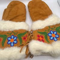 Top view of both mittens showing beadwork, fur trim and suede fringe