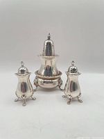 Front view of sugar caster, salt shaker, pepper shaker