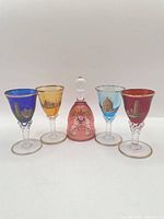 Group shot of four coloured cordial glasses and pink bell