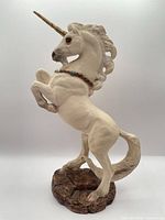 Left side view showing full unicorn pose, horn, mane, base