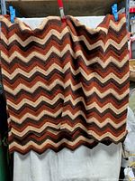 Full view of crocheted chevron afghan hanging