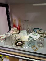 Full shelf view of mixed china, glassware and decor