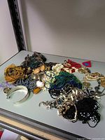 overall pile of assorted costume jewellery on shelf