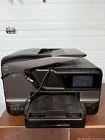 Front view of HP Officejet Pro 8600 Plus with output tray extended and power cord