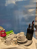Overall lot showing knives, mugs, plates, utensils