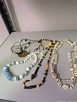 All five necklaces laid on tabletop