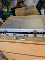 Closed silver aluminum poker chip case on dresser