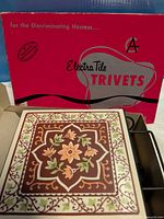 Boxed Electra Tile trivet in original packaging, showing tile pattern and box graphics