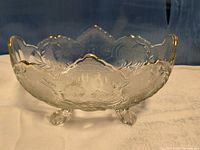 Side view of clear pressed glass footed bowl with gold-trimmed scalloped rim