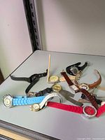 Group of assorted wristwatches on shelf