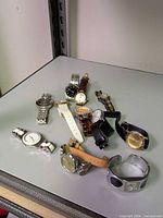 Group of assorted wristwatches on shelf