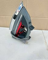 Left side profile showing brand name Shark, red reservoir, stainless soleplate, wrapped cord