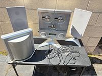 Full system view: stereo unit, two satellite speakers, subwoofer, cables