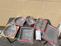 All six Technique pans in plastic on table