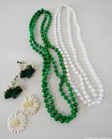 Full lot showing two bead necklaces, two pairs of earrings