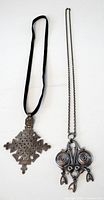 Both necklaces side by side showing pendant designs, cords, overall condition