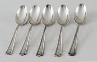 Front view of five matching sterling spoons