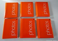 Front view of six orange photo albums numbered 1-6