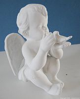 Front view of white ceramic angel figurine holding dove