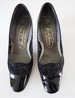 top view of both shoes showing patent leather finish, lace trim, and insole branding